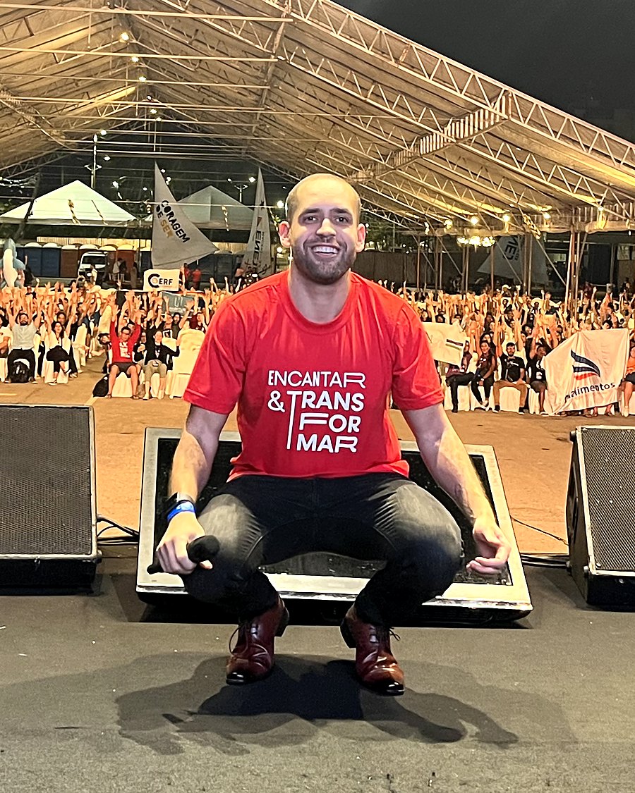 Octávio Serpa, host do Workshop, sorrindo em um palco diante do público